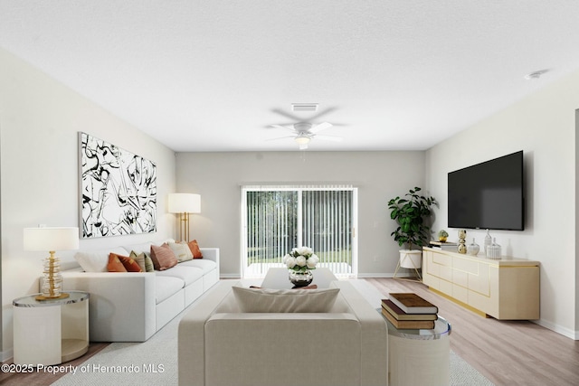 living area with a ceiling fan, visible vents, light wood-style flooring, and baseboards