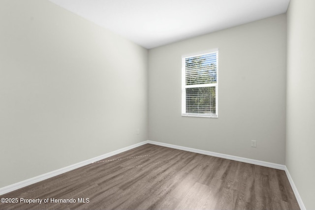 unfurnished room with wood finished floors and baseboards