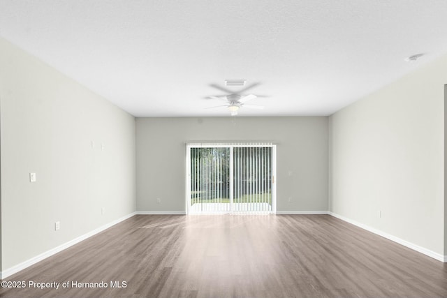 unfurnished room with ceiling fan, baseboards, and wood finished floors