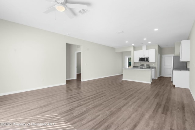 unfurnished living room with ceiling fan, recessed lighting, wood finished floors, visible vents, and baseboards