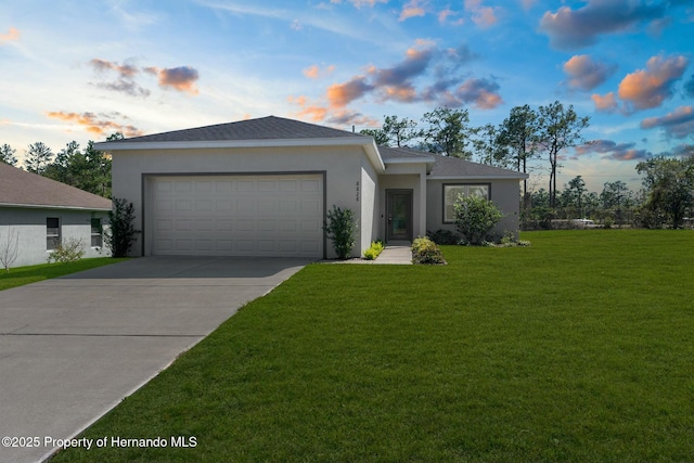 view of front of house featuring a garage, concrete driveway, a front yard, and stucco siding