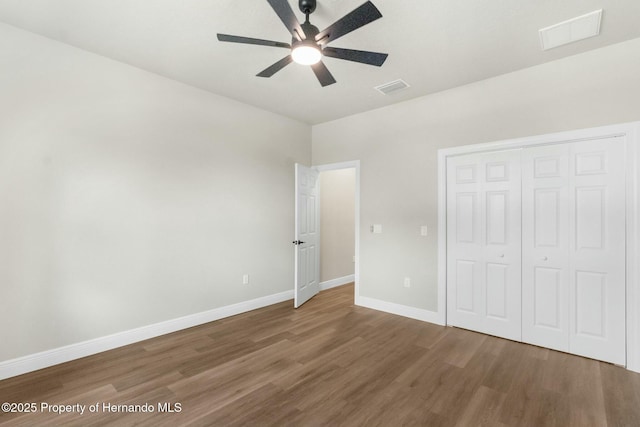 unfurnished bedroom with visible vents, baseboards, and wood finished floors