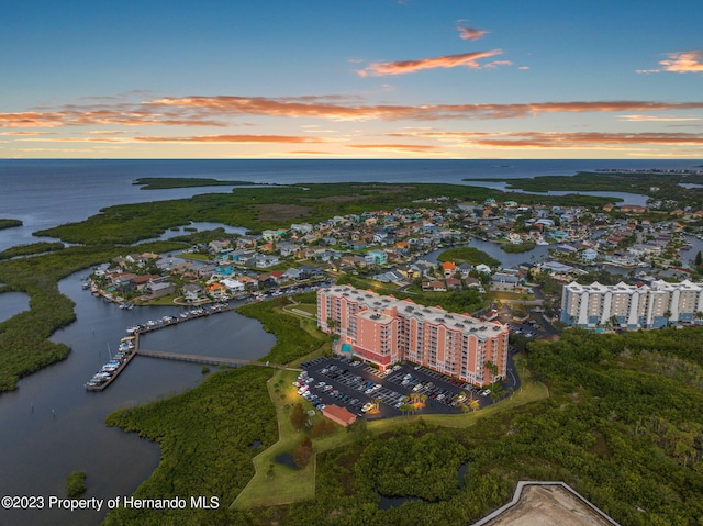 aerial view at dusk featuring a water view