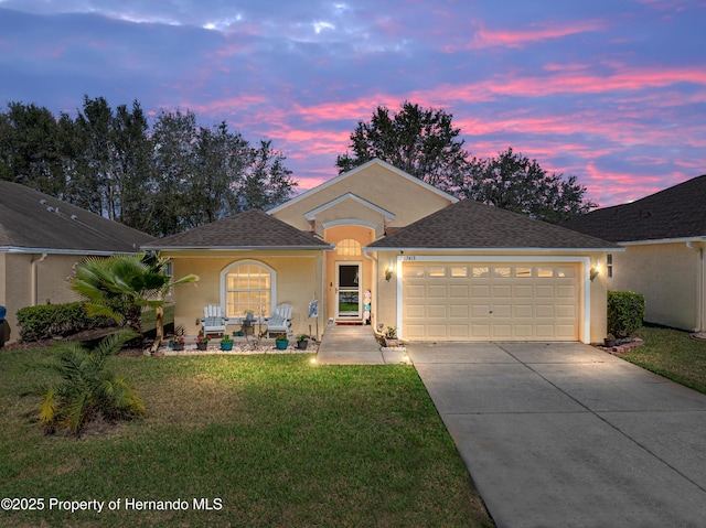 single story home with a garage, driveway, a front lawn, and stucco siding