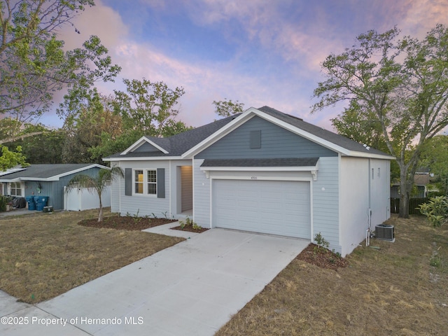 ranch-style home with a garage, driveway, a front lawn, and central AC