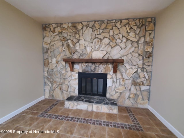 room details featuring a stone fireplace and baseboards