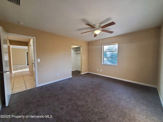 unfurnished bedroom featuring carpet, visible vents, ceiling fan, baseboards, and tile patterned floors