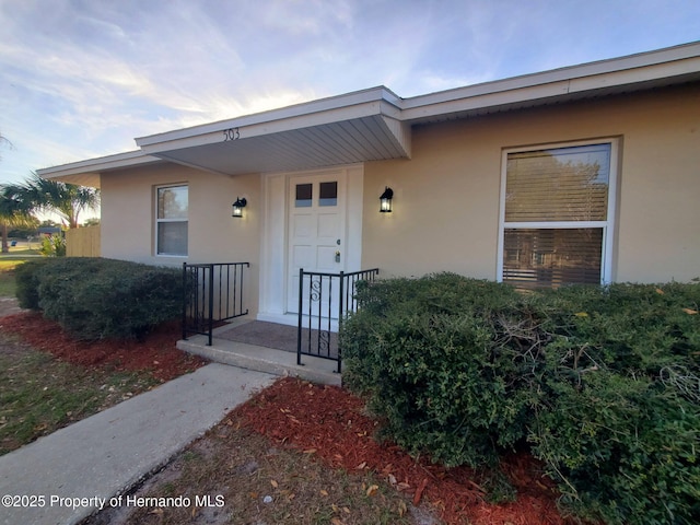 view of exterior entry featuring stucco siding