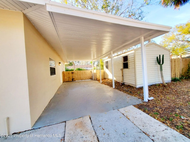 view of patio / terrace with a shed, fence, and an outdoor structure