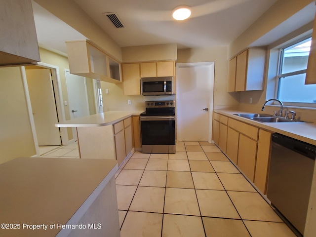 kitchen featuring stainless steel appliances, light countertops, visible vents, light brown cabinets, and a sink