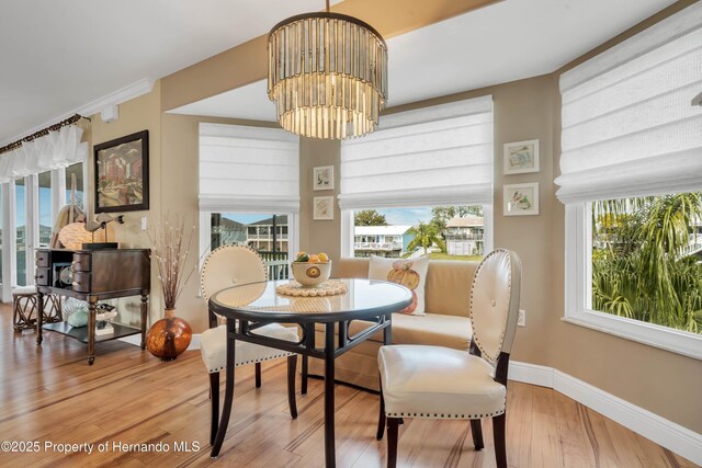 dining room with an inviting chandelier, baseboards, and wood finished floors