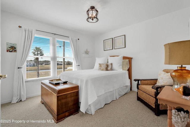 bedroom featuring light colored carpet and baseboards