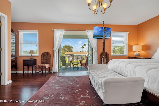 bedroom with access to exterior, dark wood finished floors, baseboards, and an inviting chandelier