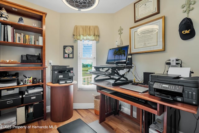 home office featuring plenty of natural light, baseboards, and wood finished floors