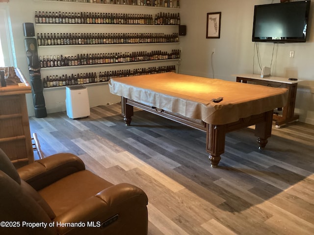 recreation room with pool table, a bar, and wood finished floors