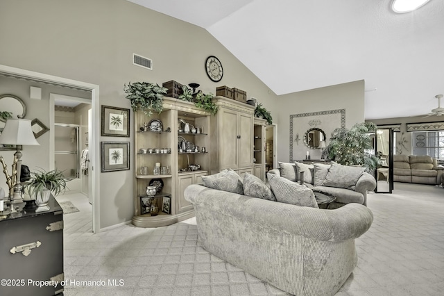 living room with high vaulted ceiling, light colored carpet, visible vents, and ceiling fan