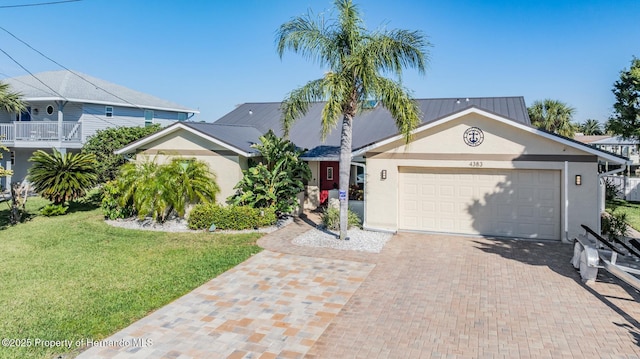 view of front facade with a garage, a front lawn, decorative driveway, and stucco siding