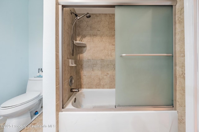 bathroom featuring toilet and combined bath / shower with glass door