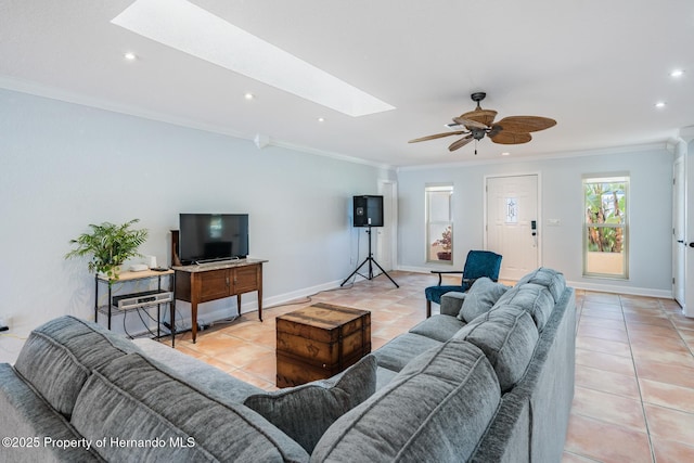 living area featuring ornamental molding, a skylight, light tile patterned flooring, and baseboards