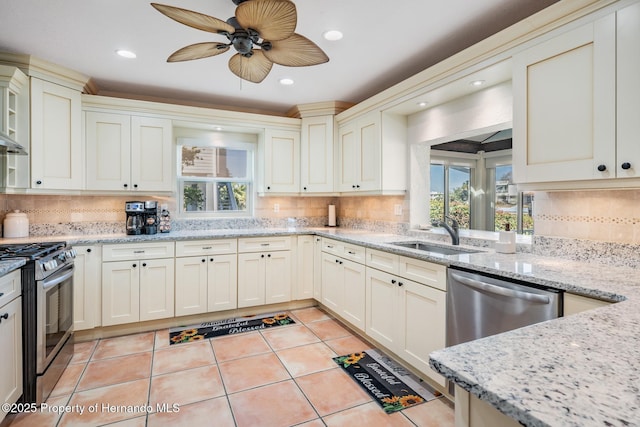 kitchen featuring light tile patterned floors, a sink, appliances with stainless steel finishes, light stone countertops, and tasteful backsplash