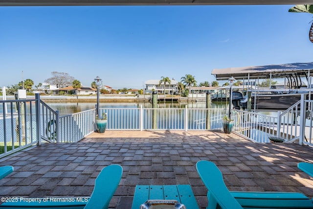 view of patio featuring a boat dock, a water view, and boat lift