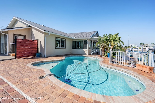 view of swimming pool featuring a fenced in pool, fence, and a patio