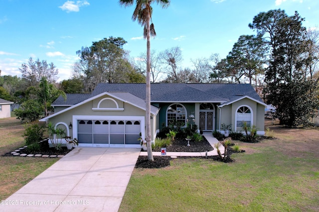 ranch-style house with driveway, an attached garage, a front yard, and stucco siding