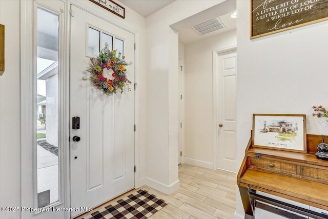 entrance foyer with baseboards, visible vents, and light wood finished floors