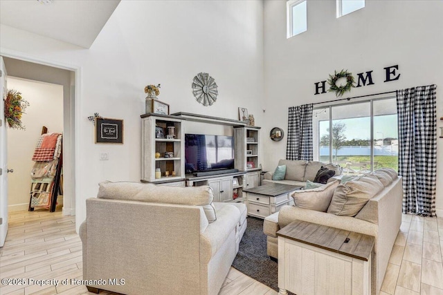 living room with a towering ceiling and wood finish floors