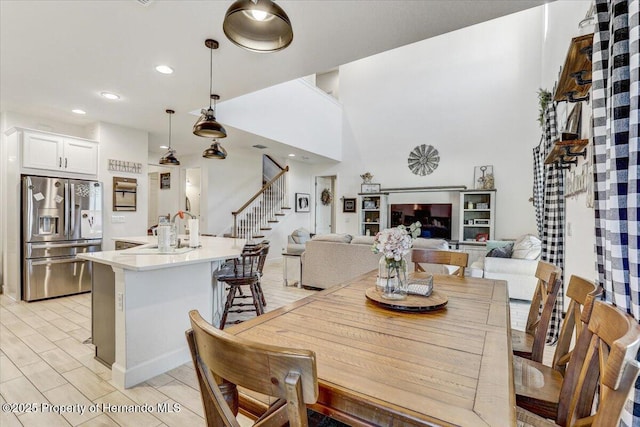 dining area with wood finish floors, recessed lighting, and stairs