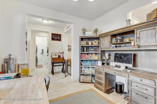 office with built in study area, light wood-type flooring, and baseboards