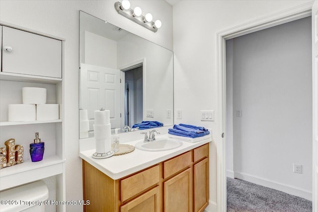 bathroom with vanity, toilet, and baseboards