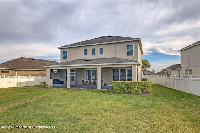 back of property with a patio area, a yard, a fenced backyard, and stucco siding