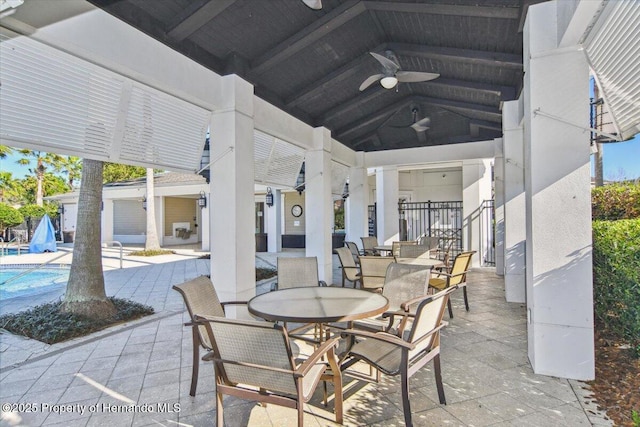 view of patio with outdoor dining space, a ceiling fan, and an outdoor pool