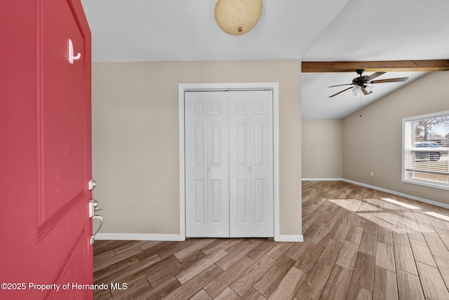 foyer featuring vaulted ceiling with beams, baseboards, a ceiling fan, and wood tiled floor