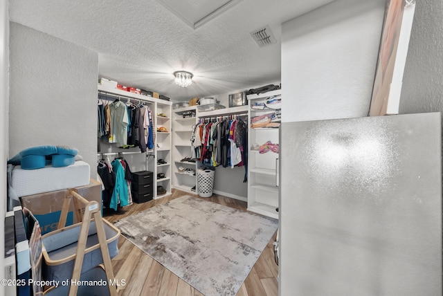 spacious closet featuring visible vents and wood finished floors