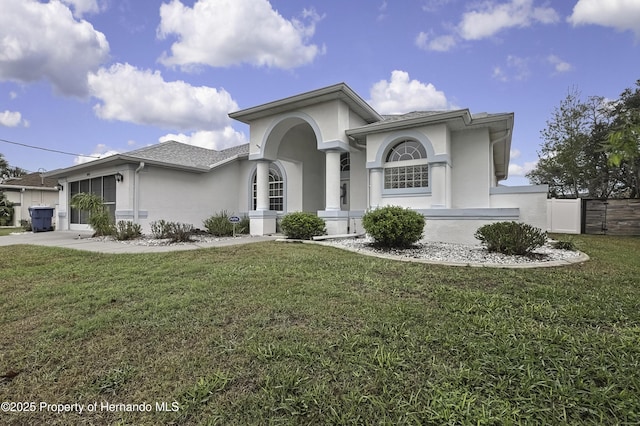 mediterranean / spanish home featuring a garage, roof with shingles, a front lawn, and stucco siding