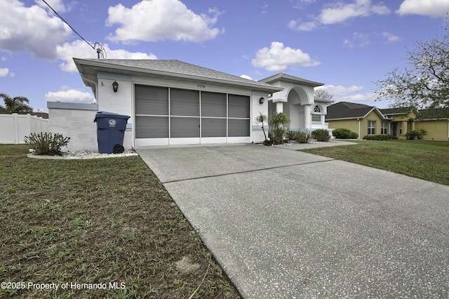 prairie-style home featuring a garage, a shingled roof, concrete driveway, a front lawn, and stucco siding