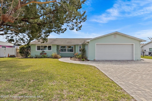 single story home with a front yard, decorative driveway, fence, and an attached garage