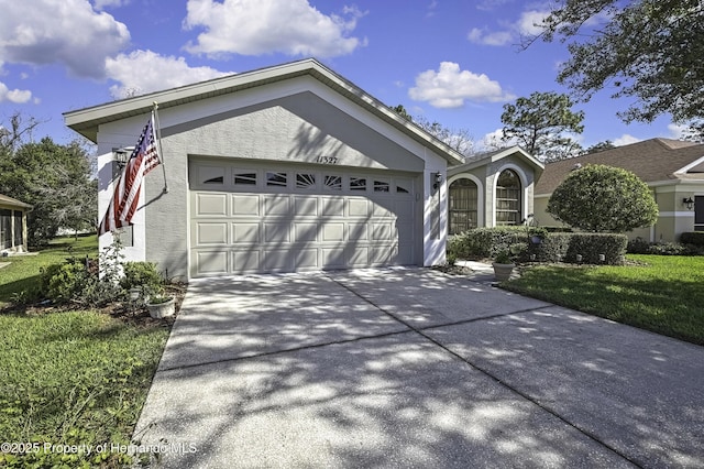 ranch-style house featuring a garage, driveway, and stucco siding