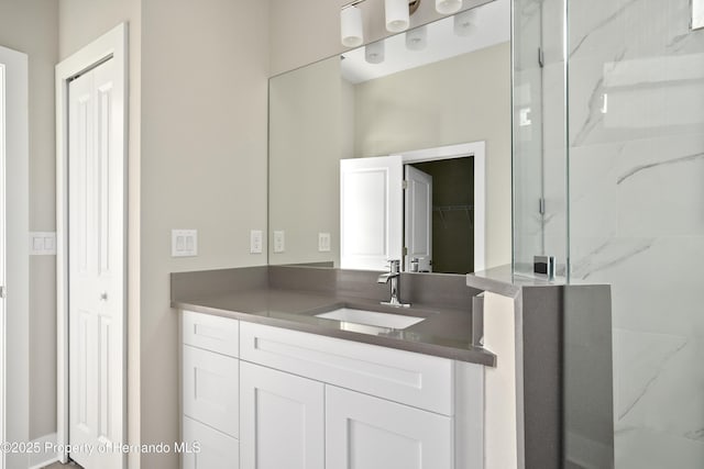 full bathroom featuring vanity and a marble finish shower