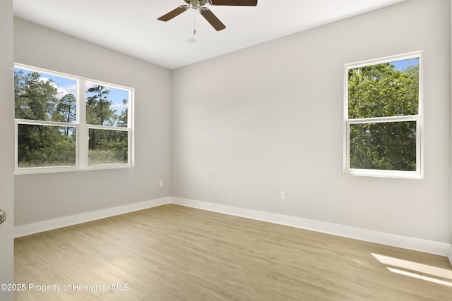 unfurnished room featuring plenty of natural light, light wood-style floors, and baseboards