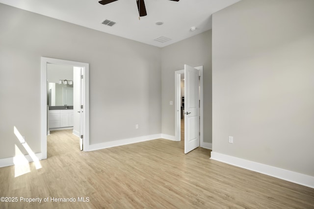 unfurnished bedroom with light wood-style floors, visible vents, ensuite bathroom, and baseboards