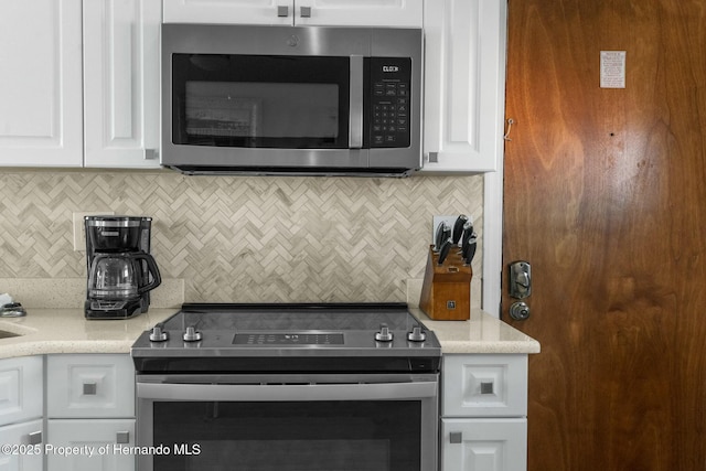 kitchen featuring white cabinets, tasteful backsplash, and stainless steel appliances