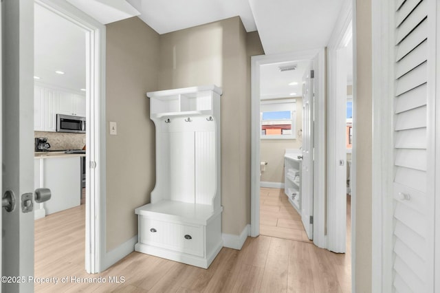 mudroom with light wood-style flooring, visible vents, and baseboards