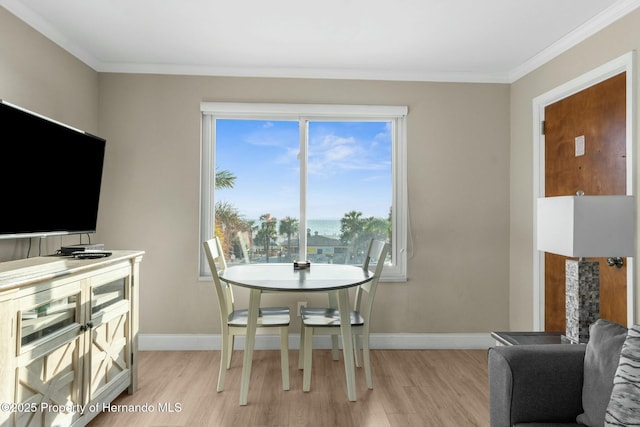 dining space with light wood-style flooring, baseboards, and ornamental molding