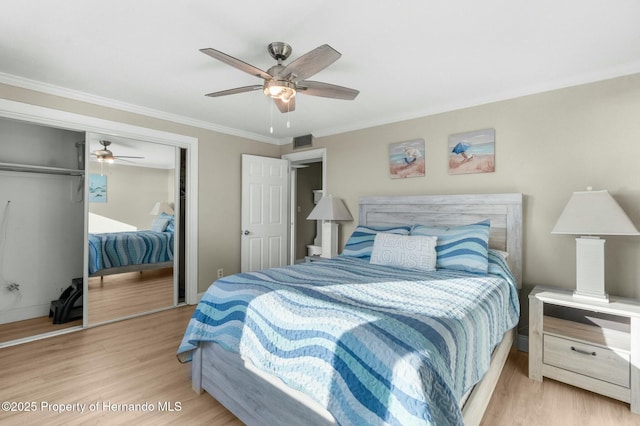 bedroom with crown molding, ceiling fan, a closet, and wood finished floors