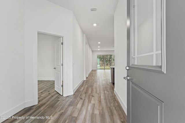 hall with visible vents, recessed lighting, wood finished floors, and baseboards