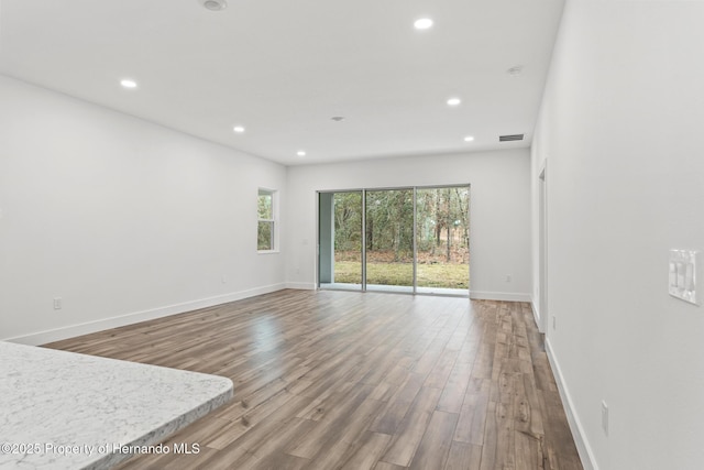 unfurnished room featuring recessed lighting, visible vents, baseboards, and wood finished floors