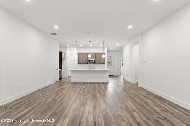 unfurnished living room with recessed lighting, light wood-style floors, visible vents, and baseboards